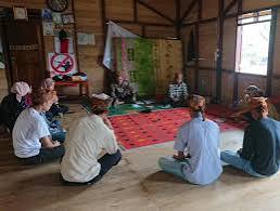 Seorang pengrajin sedang menganyam rotan